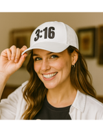 Woman wearing a white Christian trucker cap with '3:16' printed on the front panel.