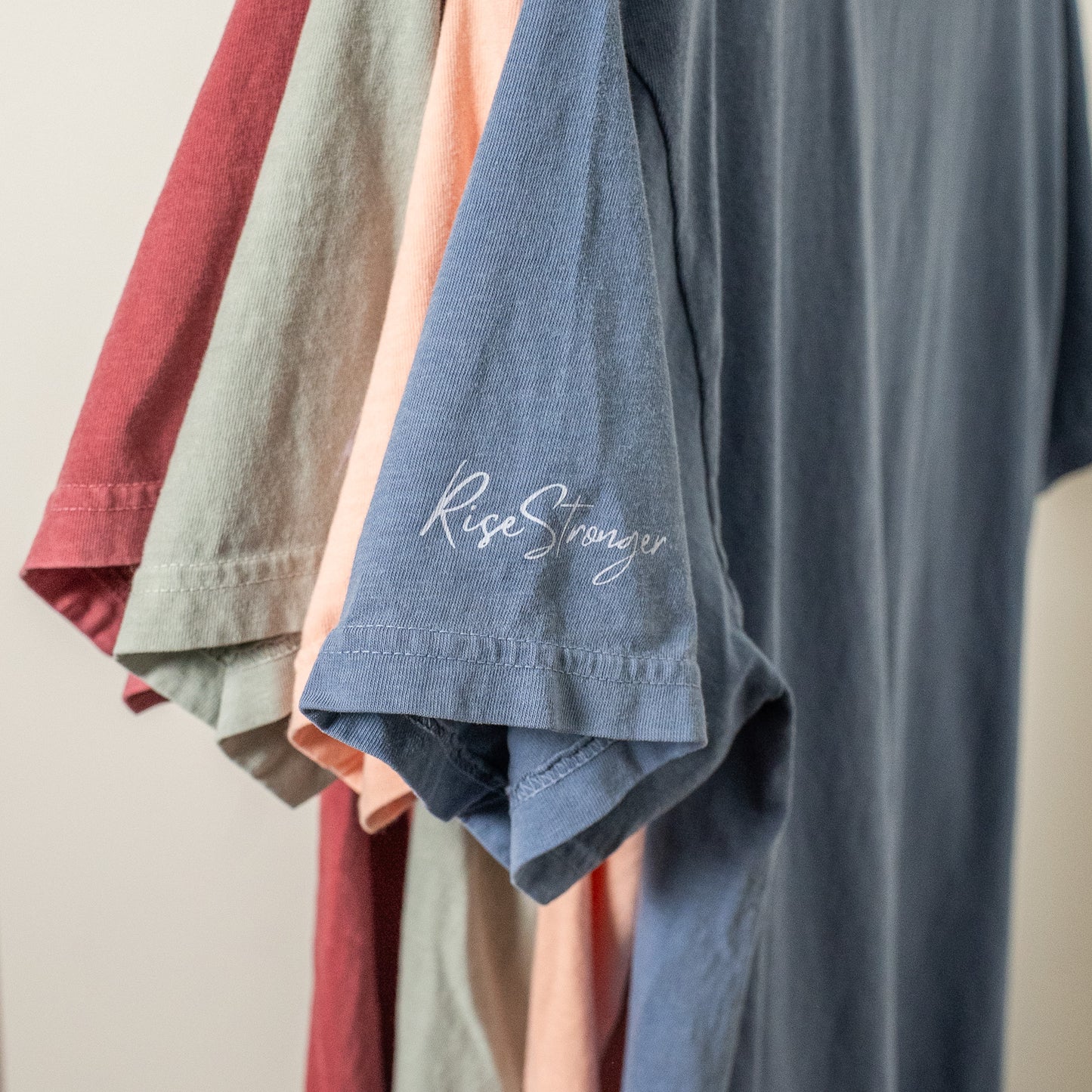 Side view of the inspirational faith-based shirt on a female model standing outdoors  