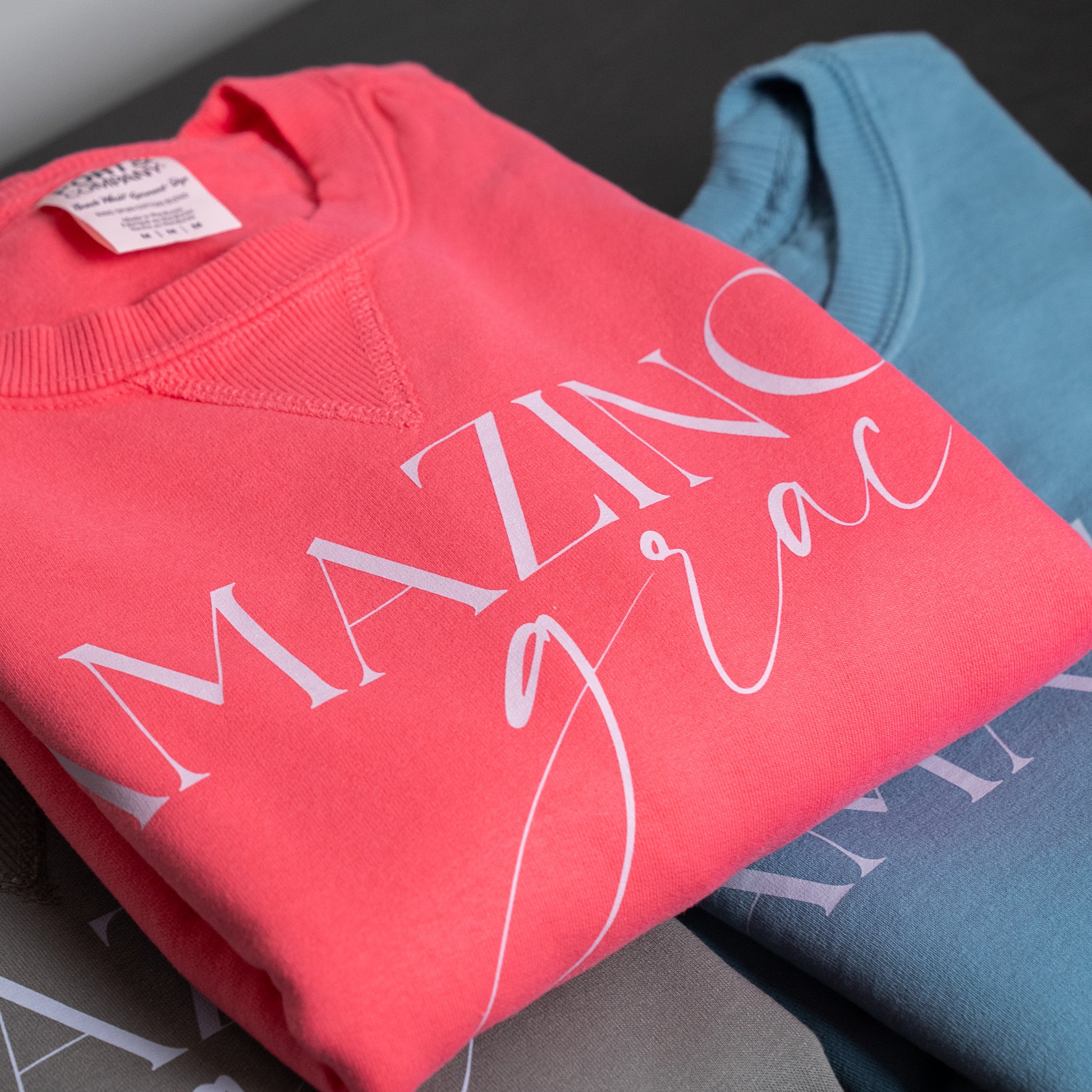Folded crewneck sweatshirt neatly displayed on a wooden surface with soft lighting