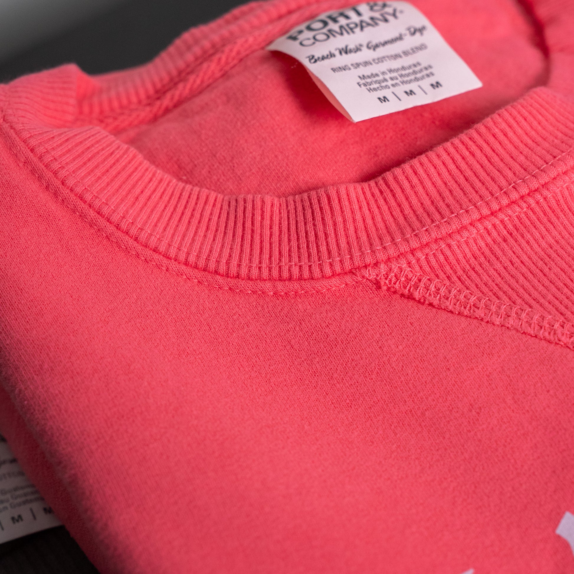 Salt + Light sweatshirt folded neatly on a wooden surface for display