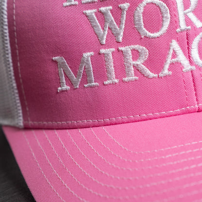 Embroidered faith statement on front of stylish pink and white trucker hat with structured crown  