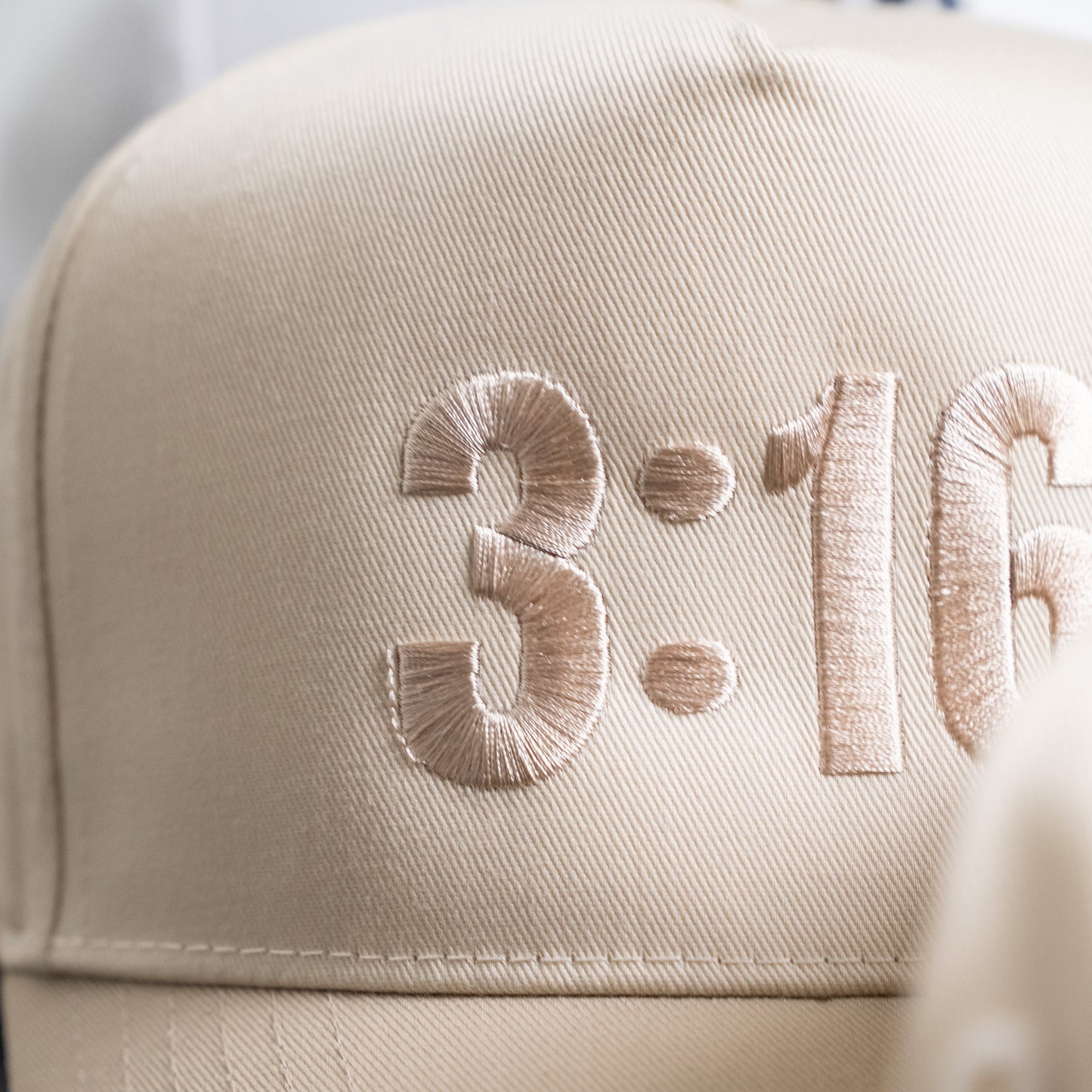 Back view showing adjustable strap on white "3:16" five-panel hat made from durable twill fabric