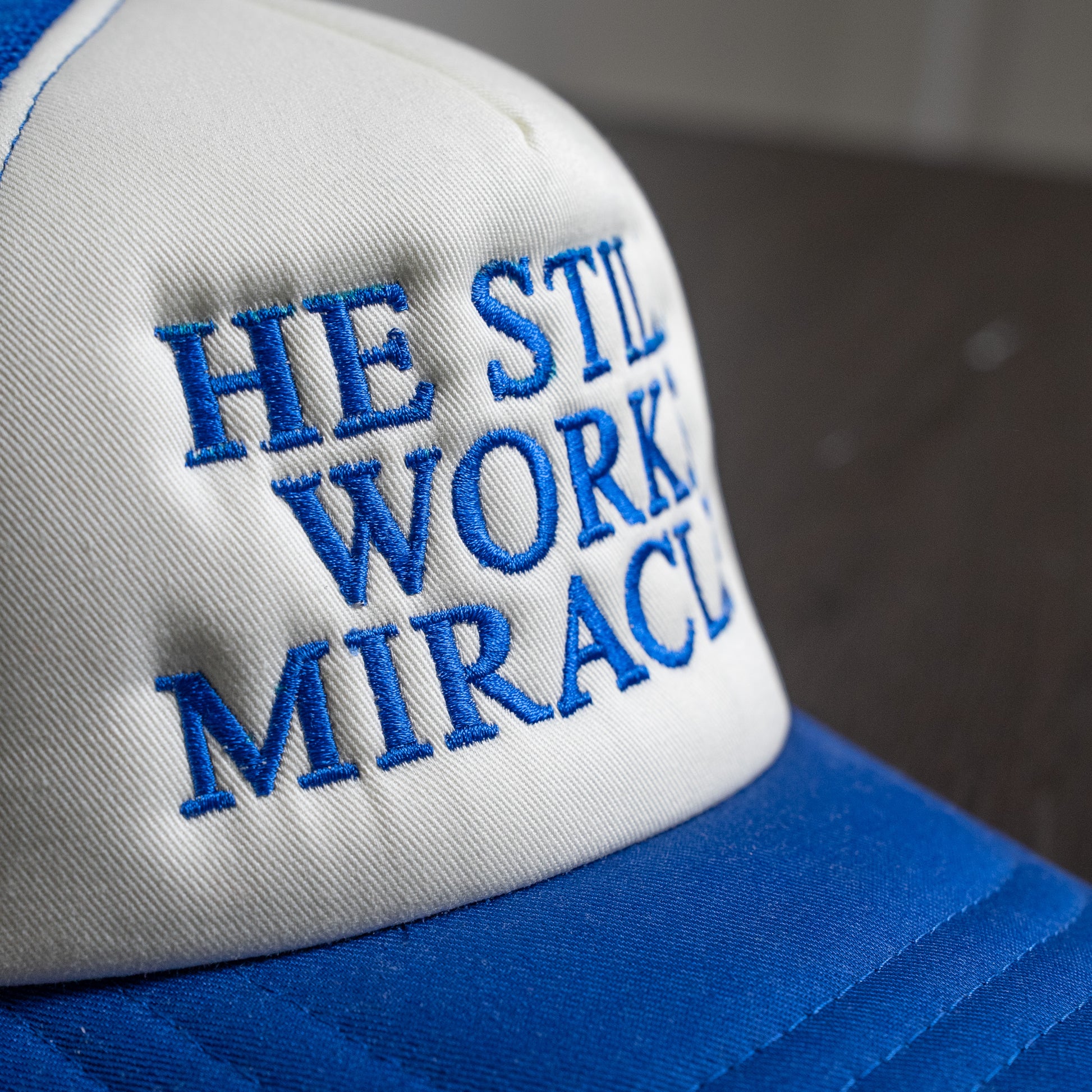 Side view of breathable pink mesh cap with snapback closure and inspirational "He Still Works Miracles" embroidery  