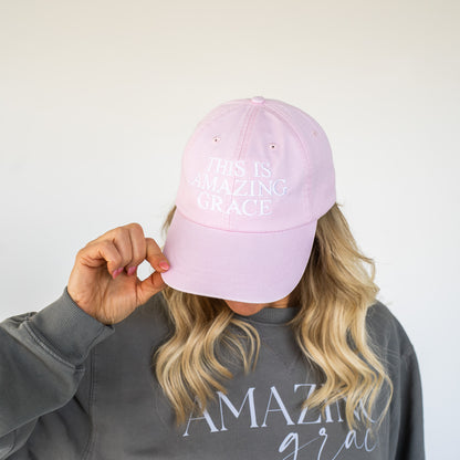 Front view of a navy blue cap with "This Is Amazing Grace" embroidered in white thread  