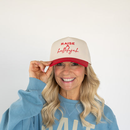Red and cream five-panel cotton twill cap with embroidered "Raise a Hallelujah" text on front  