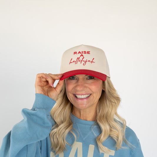 Red and cream five-panel cotton twill cap with embroidered "Raise a Hallelujah" text on front  