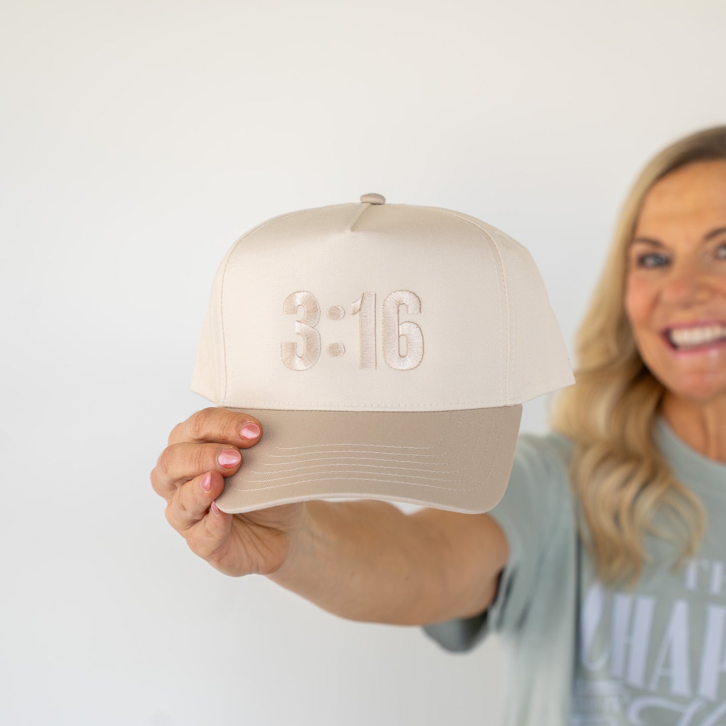 Front view of white twill cap featuring bold black stitched "3:16" emblem, designed for casual wear  