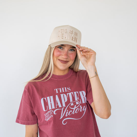 Side angle of a structured six-panel cap showing adjustable strap and embroidered text  