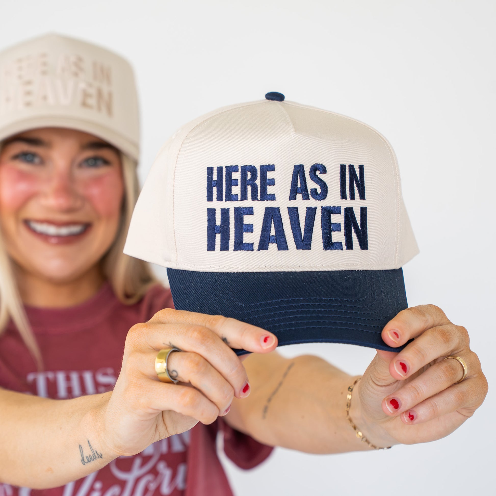 Close-up detail of white embroidery on navy blue fabric of faith-themed baseball hat  