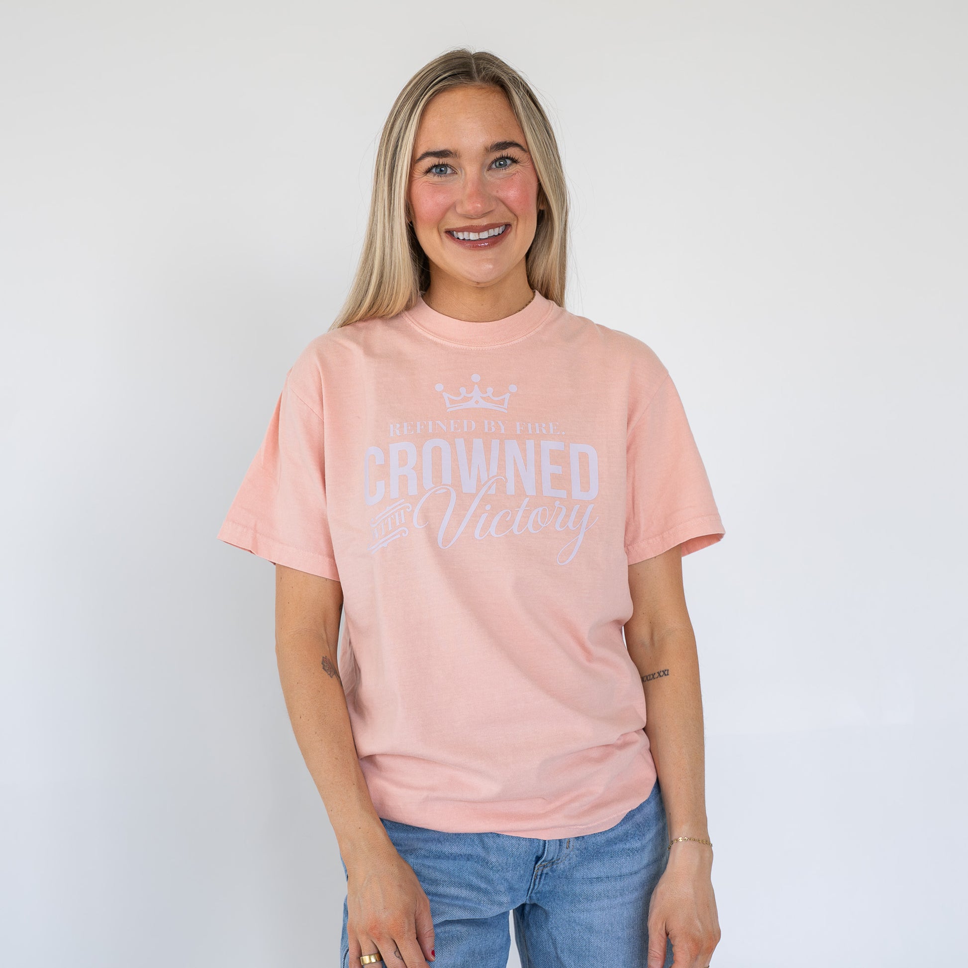 Close-up of women’s Refined by Fire t-shirt displaying bold, inspirational text  