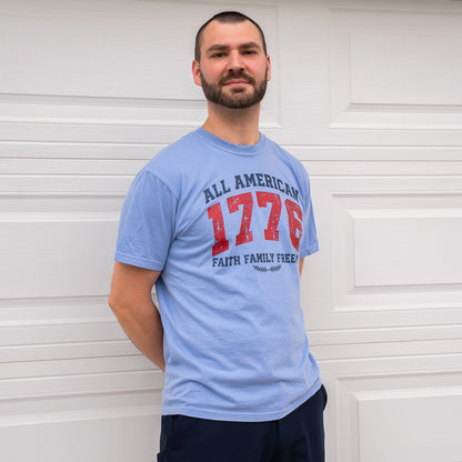 Man wearing blue 1776 All American t-shirt with bold red navy print