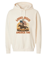 Beige Christian patriotic hoodie with an American flag and text that reads Loves Jesus and America Too.