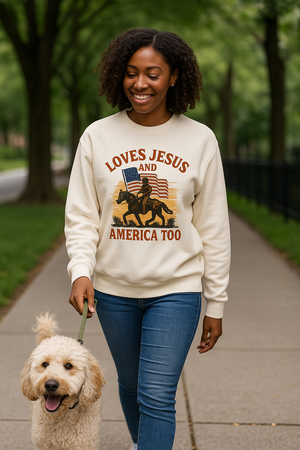 Woman wearing a beige Christian patriotic crew with an American flag and text that reads Loves Jesus and America Too.