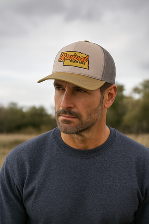 Man wearing a Christian trucker hat with 'Revival Starts Here' design overlaying an outline of the state of Nebraska.