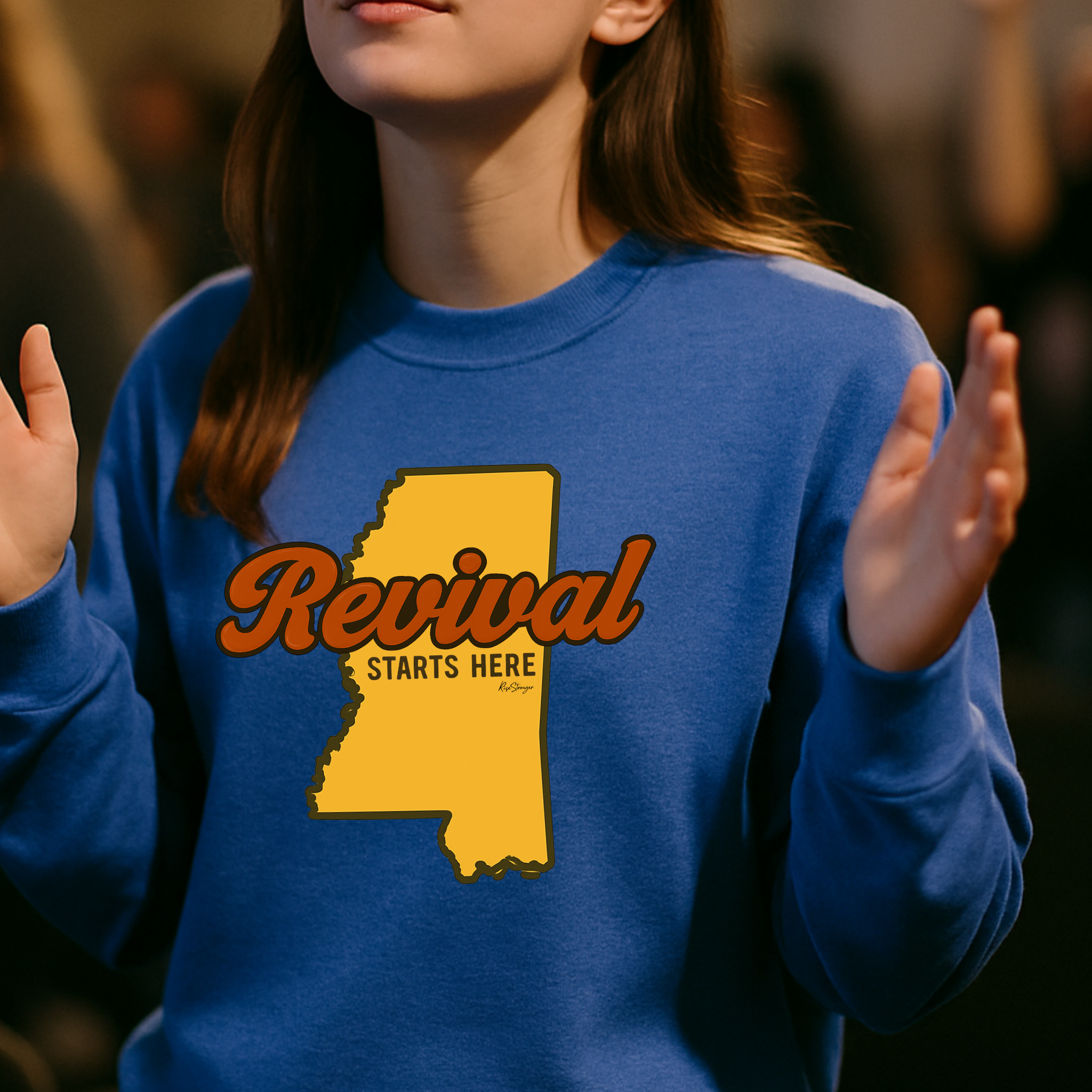 Christian female wearing a royal blue sweatshirt with 'Revival Starts Here' text overlaying the state of Mississippi.