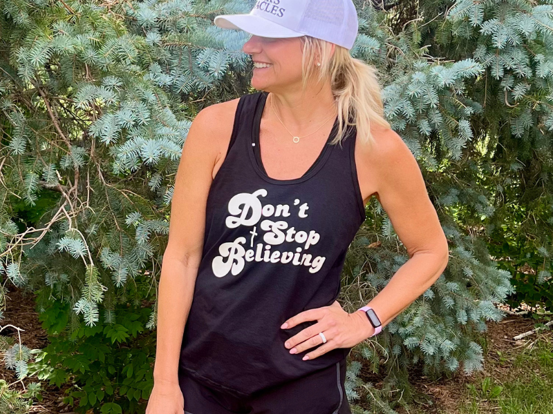 Woman wearing a Rise Stronger 'Don’t Stop Believing' Christian women’s racerback tank