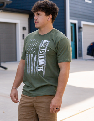 Man wearing a Christian patriotic t-shirt with a tattered American flag and Rise Stronger text on the front.
