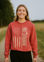 Young lady wearing a red Christian sweatshirt with Rise Stronger and an American flag printed on the front.